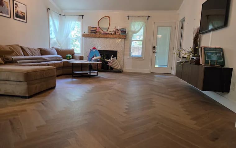 Finished herringbone wood-look flooring across an Austin living room