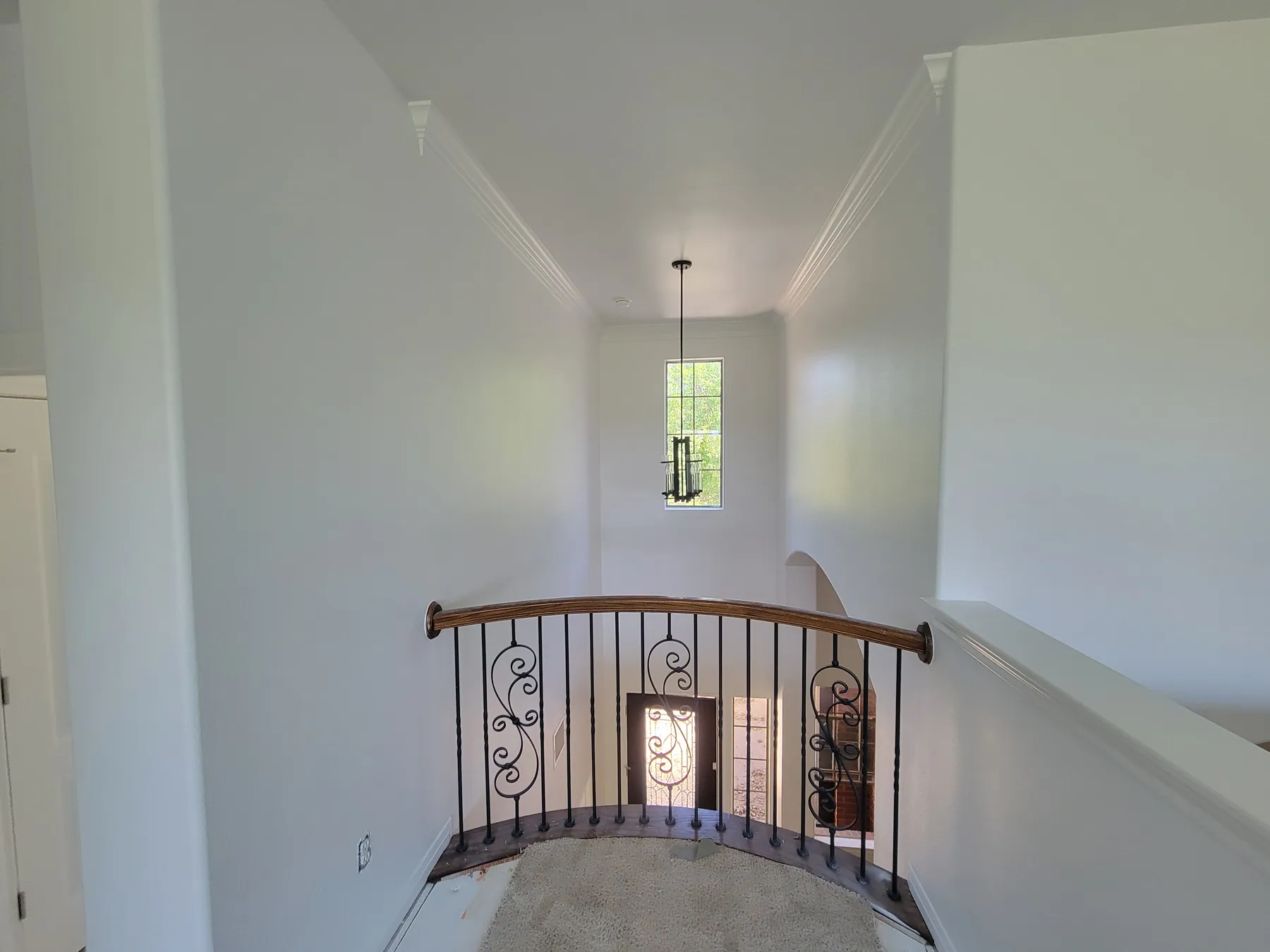 Bright Austin foyer with painted ceiling, crown molding, and stair railing