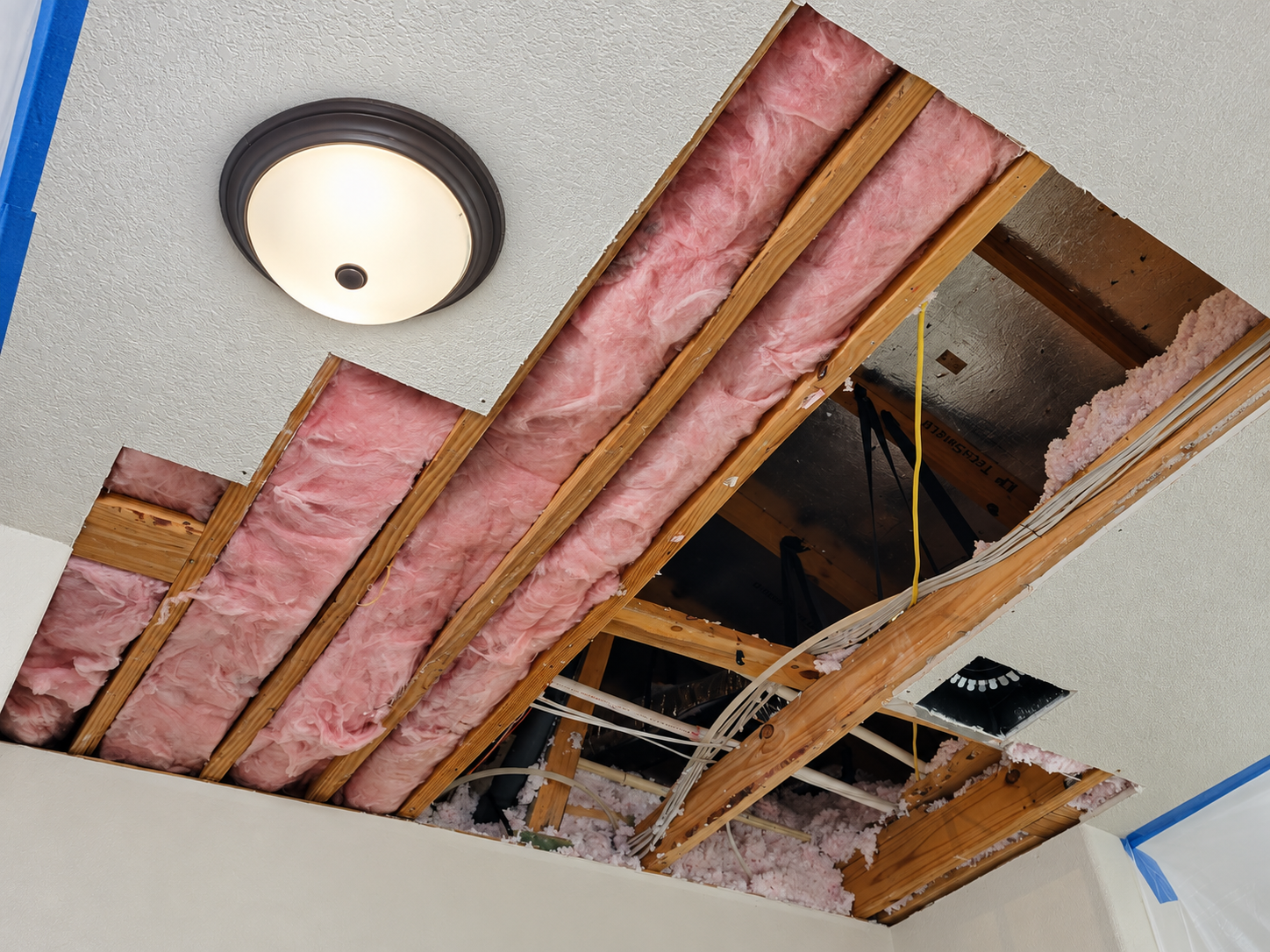 Austin ceiling opened to expose framing and pink insulation during drywall repair