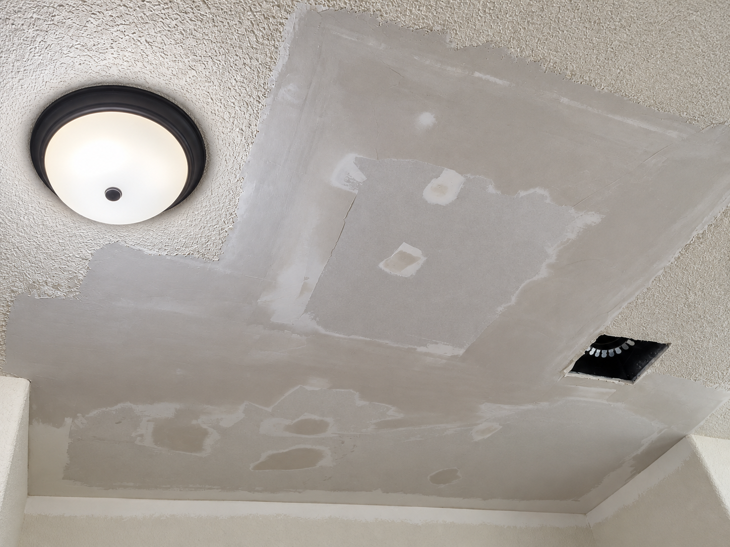 Drywall ceiling repair prepared with joint compound before final texture blending