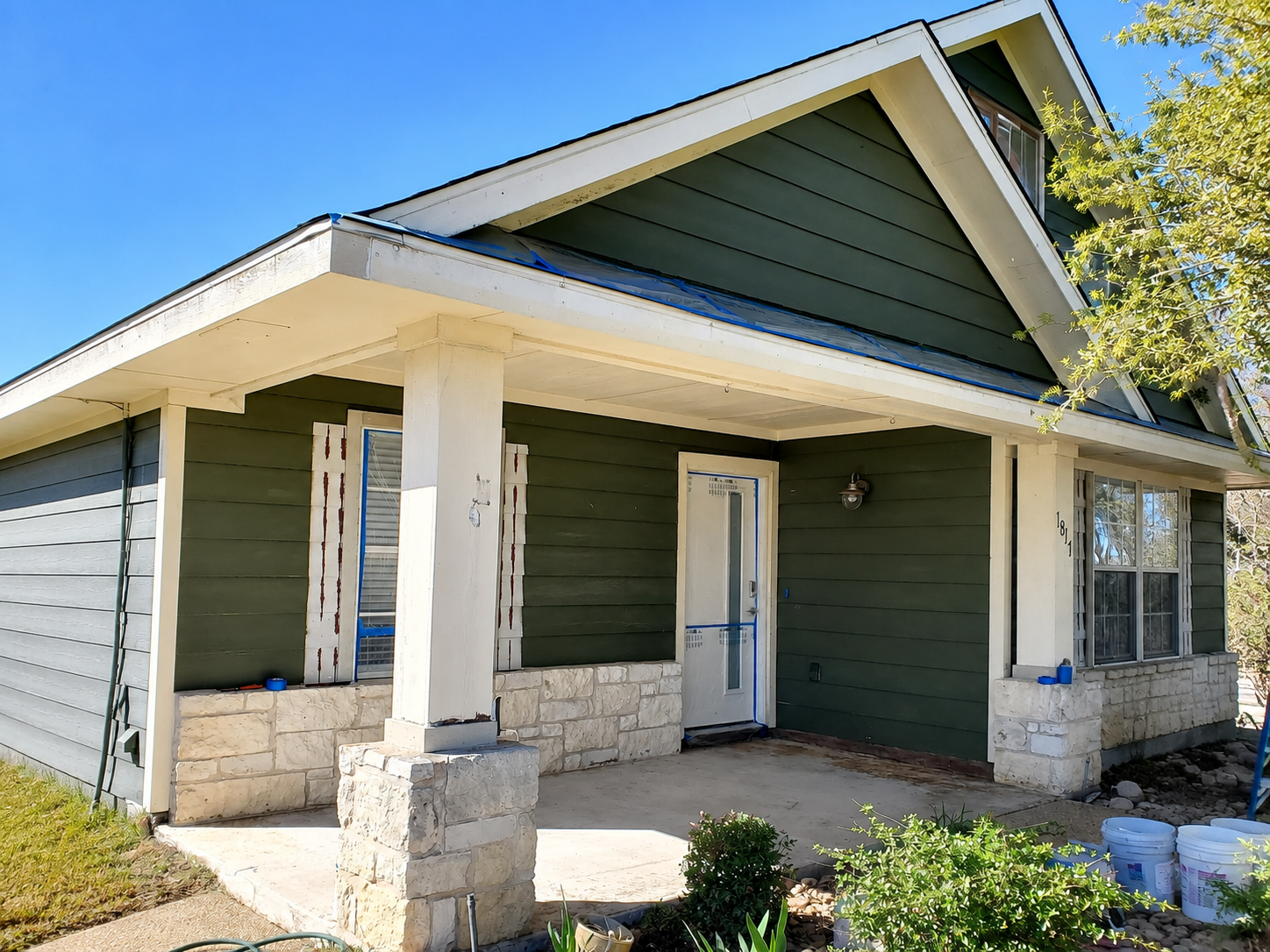 Exterior house painting preparation with masking around trim and doors