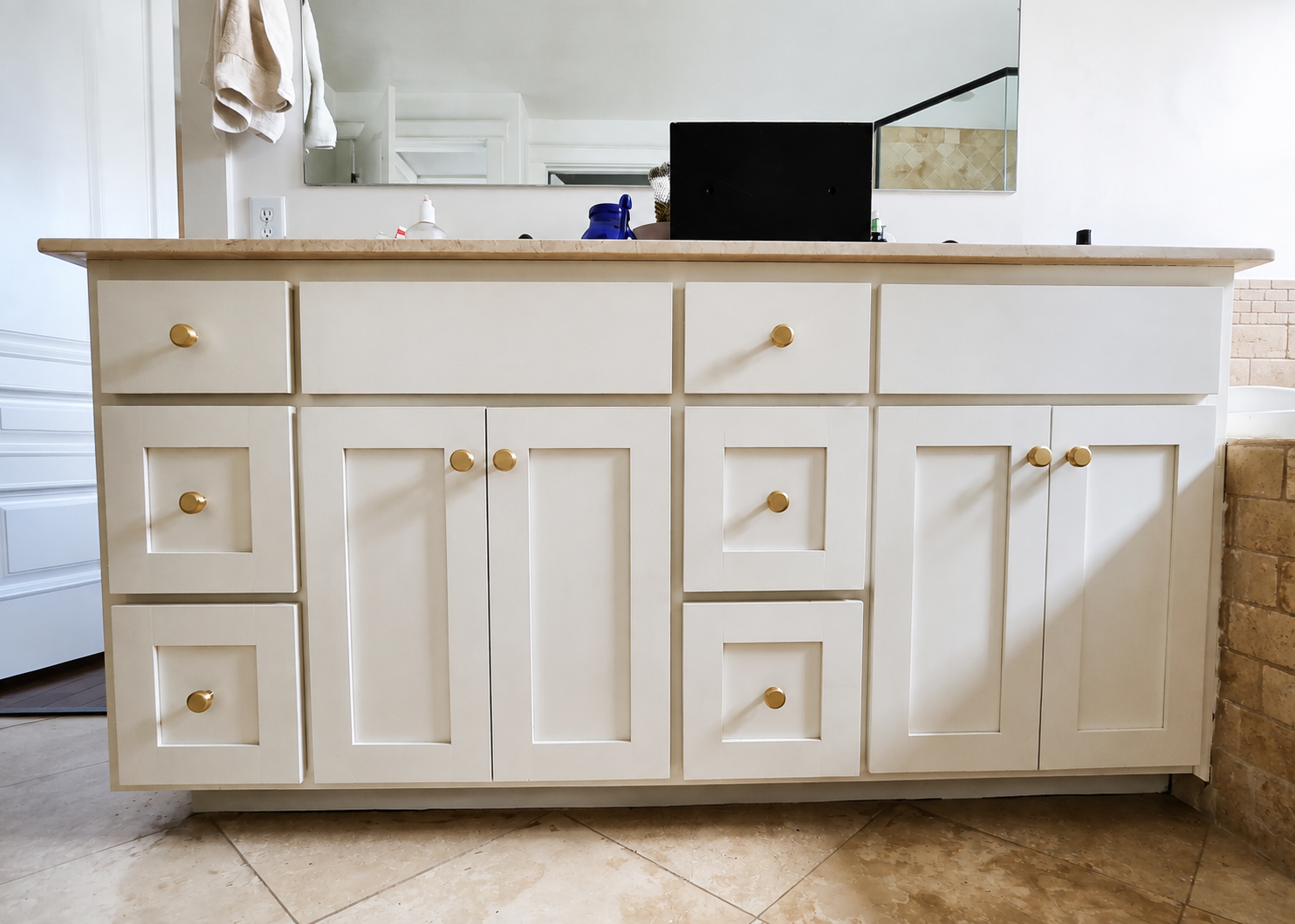 Freshly painted light cabinets with gold hardware in an Austin area bathroom