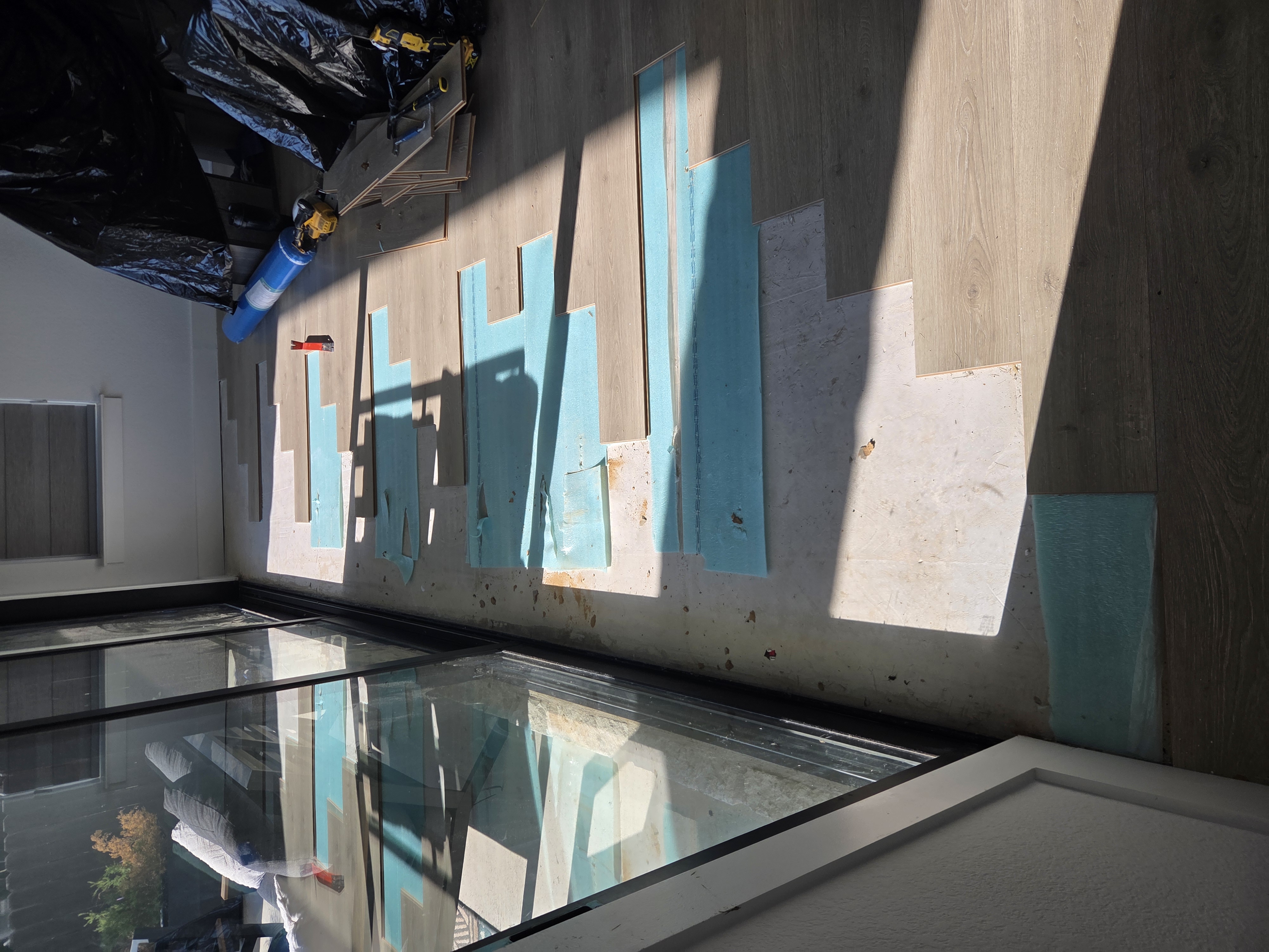 Damaged laminate removed beside the sliding glass door before floor repair