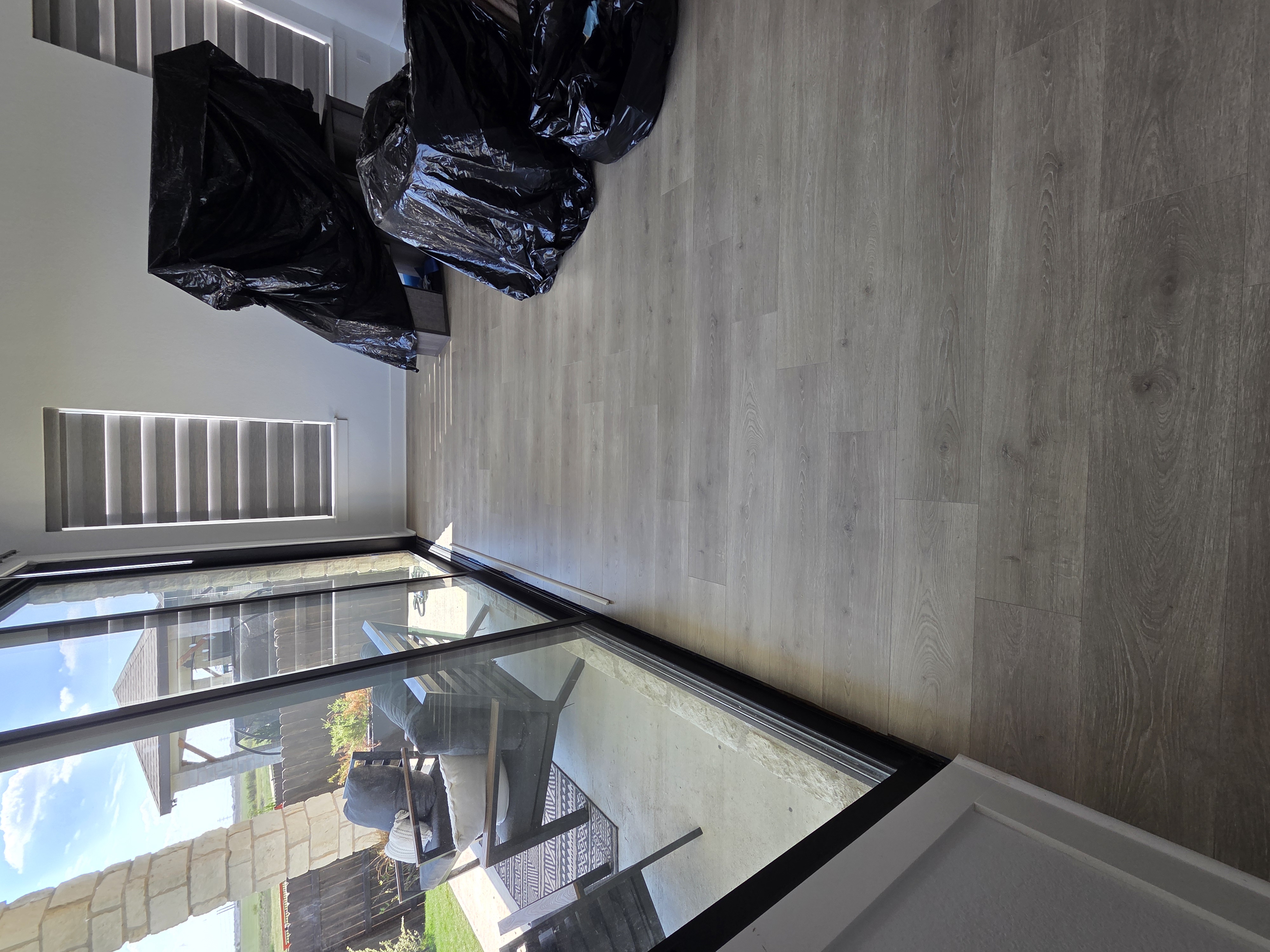 Completed laminate floor repair beside a large sliding glass door