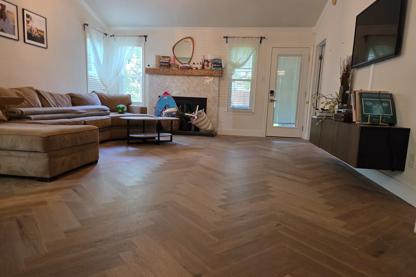 Living room with newly installed herringbone wood-look flooring