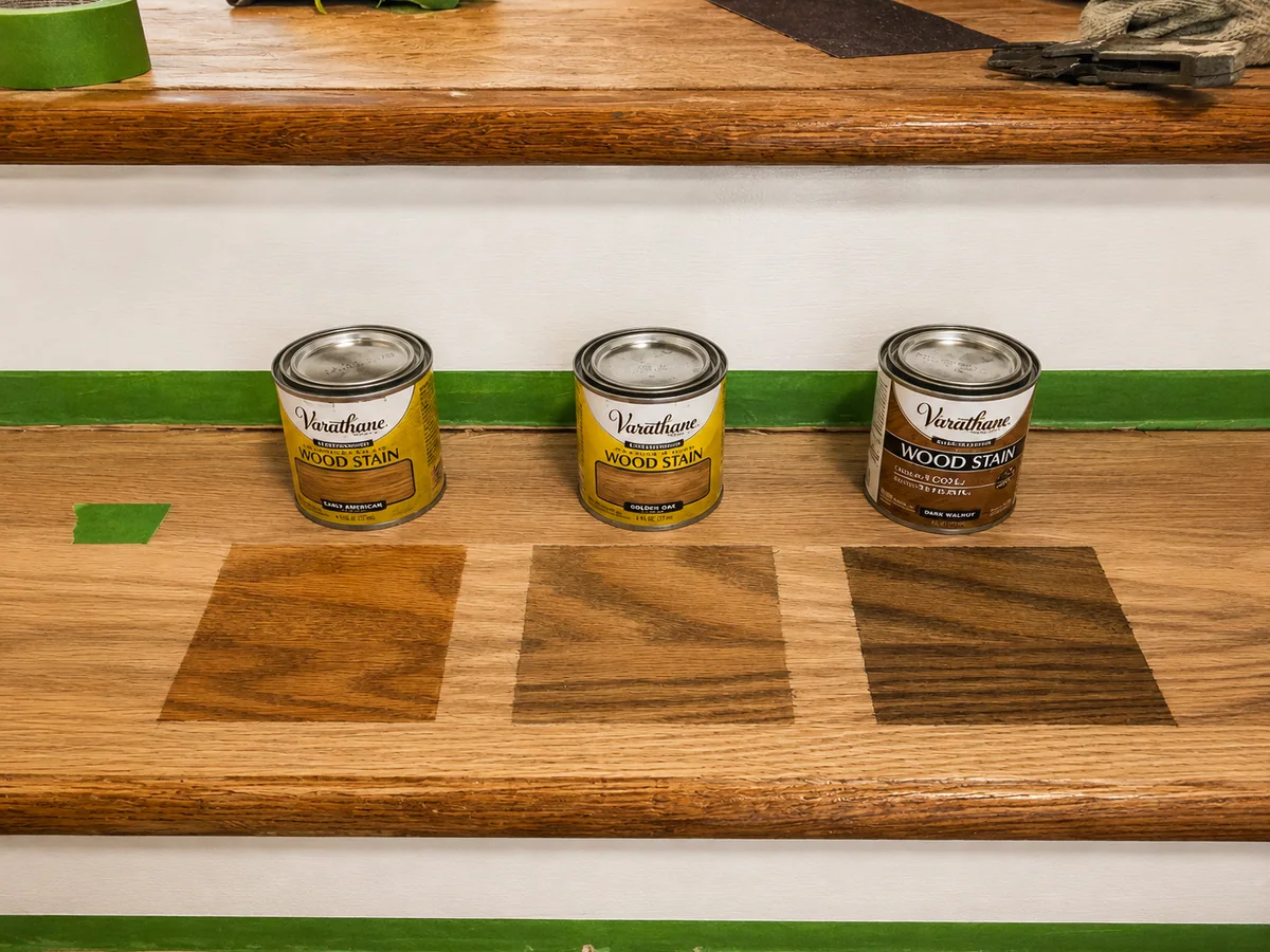 Wood stain color samples arranged on prepared staircase treads