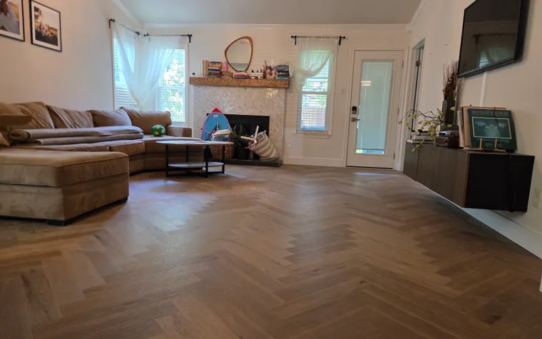 Finished herringbone wood-look flooring across an Austin living room