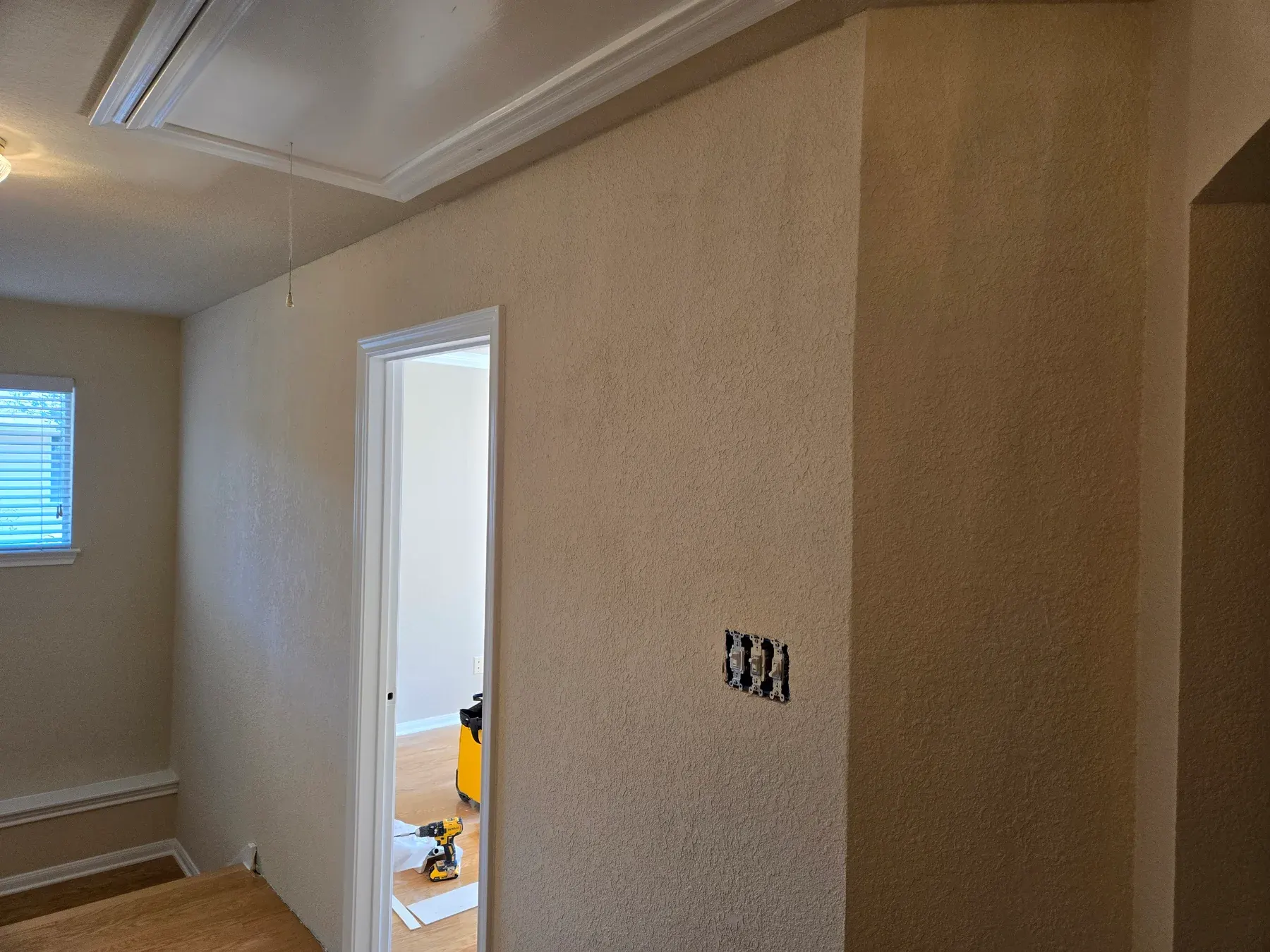 Finished textured interior wall around a white-trimmed doorway